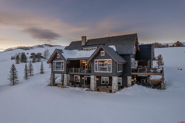 905 County Road 317, Crested Butte, CO 81224 - snow covered property featuring a balcony, a chimney, and stone siding
