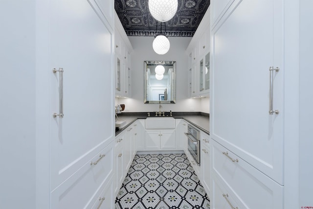 905 County Road 317, Crested Butte, CO 81224 - kitchen featuring oven, a sink, white cabinets, glass insert cabinets, and an ornate ceiling