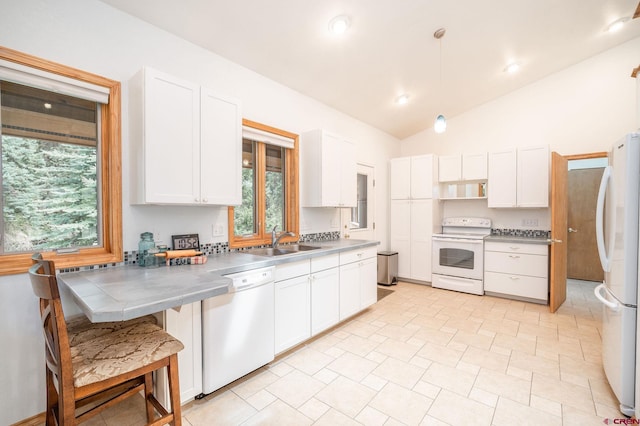 37 Verde Ln, Durango, CO 81301 - kitchen with white appliances, a sink, white cabinets, lofted ceiling, and decorative light fixtures