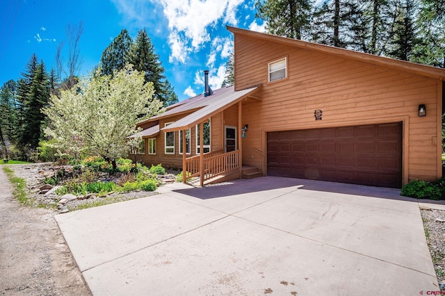 37 Verde Ln, Durango, CO 81301 - rustic home featuring a garage, concrete driveway, and metal roof