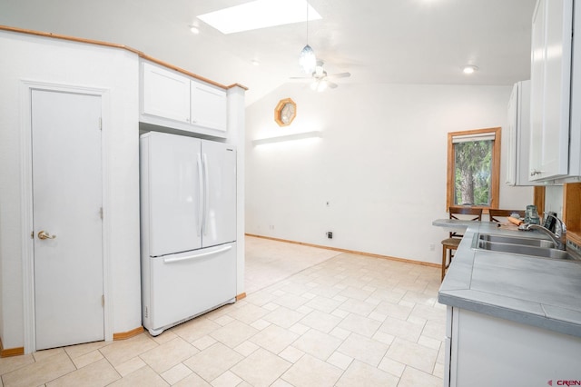 37 Verde Ln, Durango, CO 81301 - kitchen featuring freestanding refrigerator, a sink, a skylight, ceiling fan, and white cabinetry
