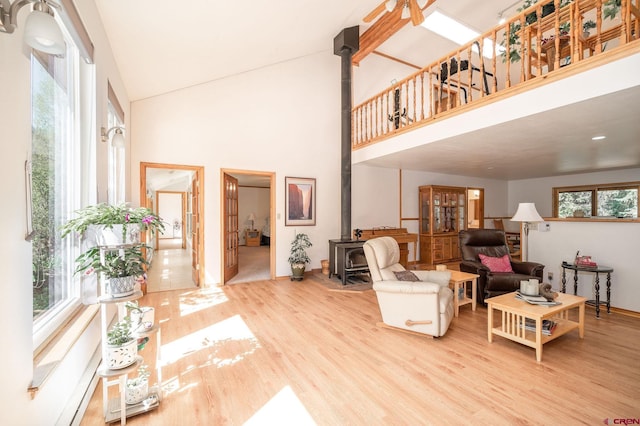 37 Verde Ln, Durango, CO 81301 - living room with a wood stove, wood finished floors, a high ceiling, and baseboards
