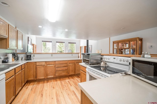 37 Verde Ln, Durango, CO 81301 - kitchen with white appliances, light wood-style floors, a peninsula, recessed lighting, and light countertops