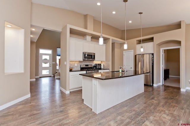 2488 Josefine Ln, Grand Junction, CO 81505 - kitchen with stainless steel appliances, decorative backsplash, a kitchen island with sink, white cabinets, and recessed lighting