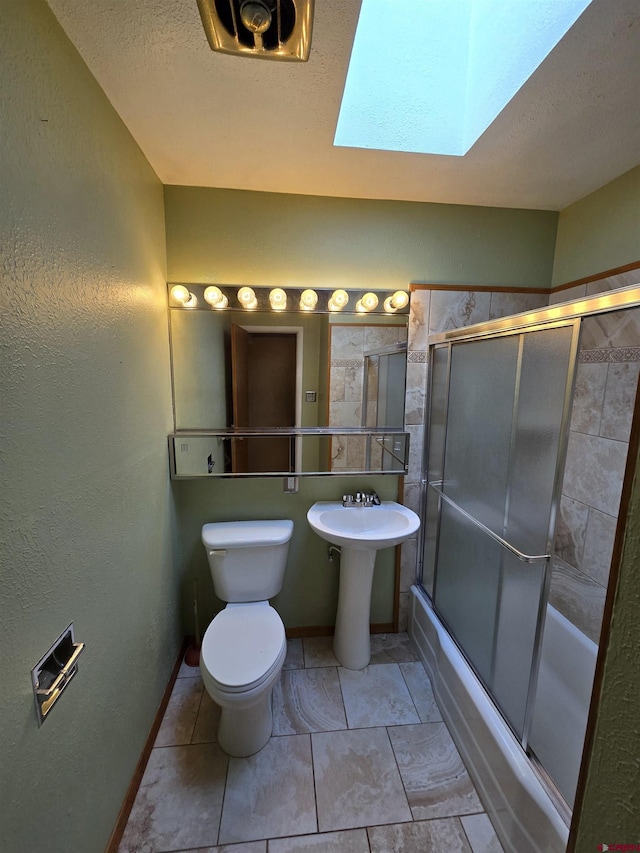 608 Alameda Dr, Cortez, CO 81321 - full bath featuring toilet, a skylight, shower / bath combination with glass door, baseboards, and a sink