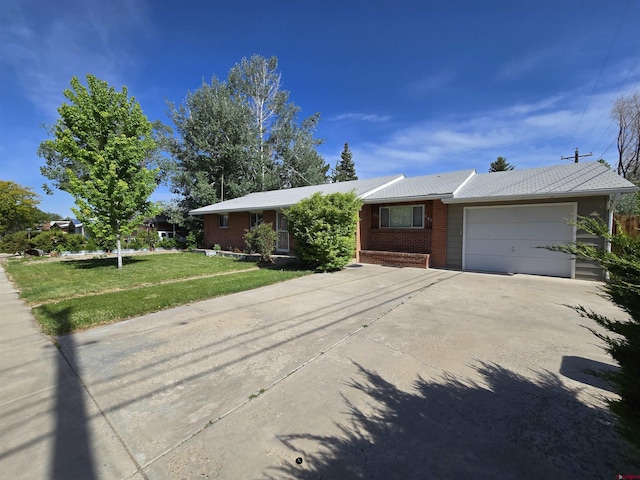 608 Alameda Dr, Cortez, CO 81321 - single story home featuring brick siding, an attached garage, concrete driveway, and a front yard