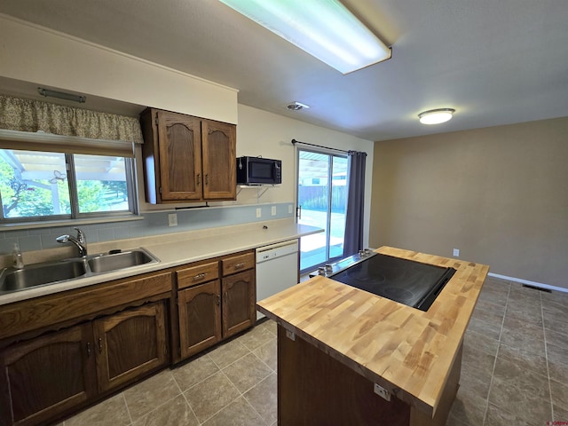 608 Alameda Dr, Cortez, CO 81321 - kitchen with butcher block counters, a sink, white dishwasher, black microwave, and a center island