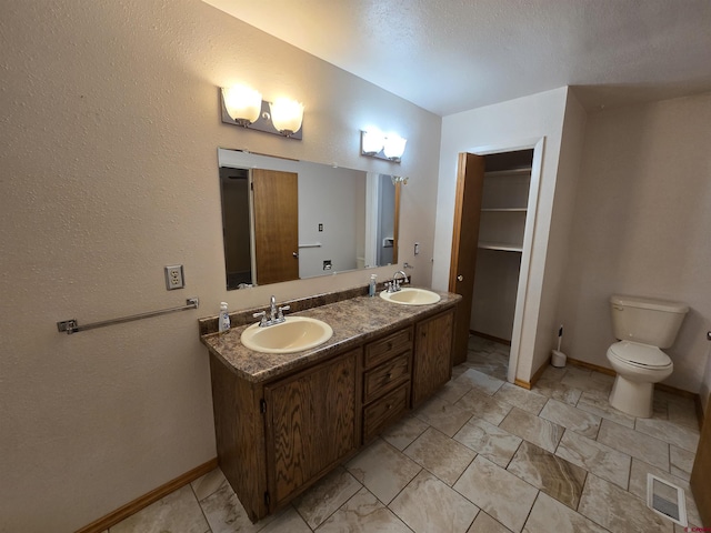 608 Alameda Dr, Cortez, CO 81321 - bathroom featuring double vanity, baseboards, and toilet