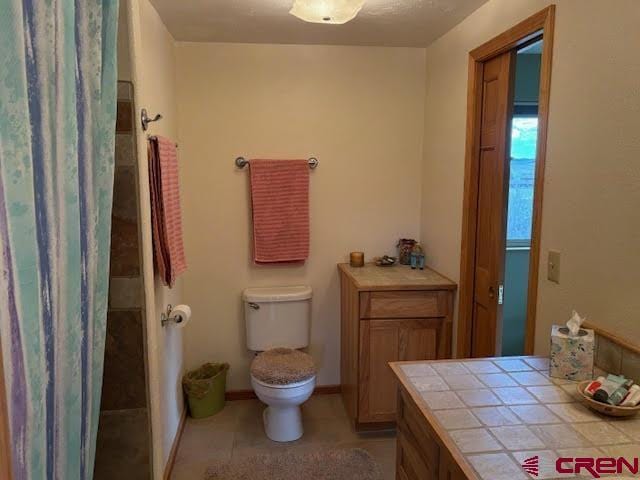 250 Pashuta Dr, Gunnison, CO 81230 - full bath with toilet, vanity, tile patterned flooring, and curtained shower
