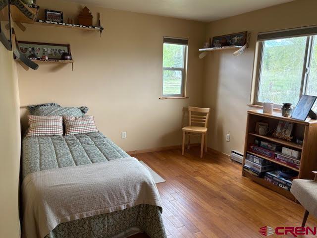 250 Pashuta Dr, Gunnison, CO 81230 - bedroom with wood finished floors, a baseboard radiator, and baseboards