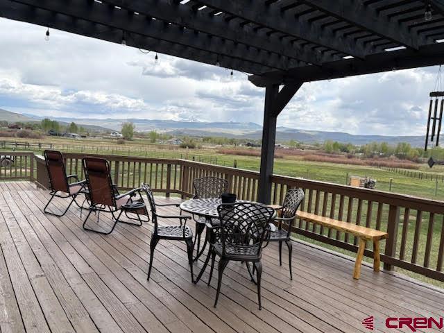 250 Pashuta Dr, Gunnison, CO 81230 - wooden terrace featuring a rural view, a pergola, outdoor dining area, and a lawn