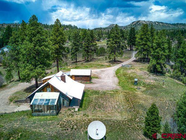 157 S Primrose Ridge Pl, Pagosa Springs, CO 81147 - aerial view of property and surrounding area featuring a heavily wooded area and a mountainous background