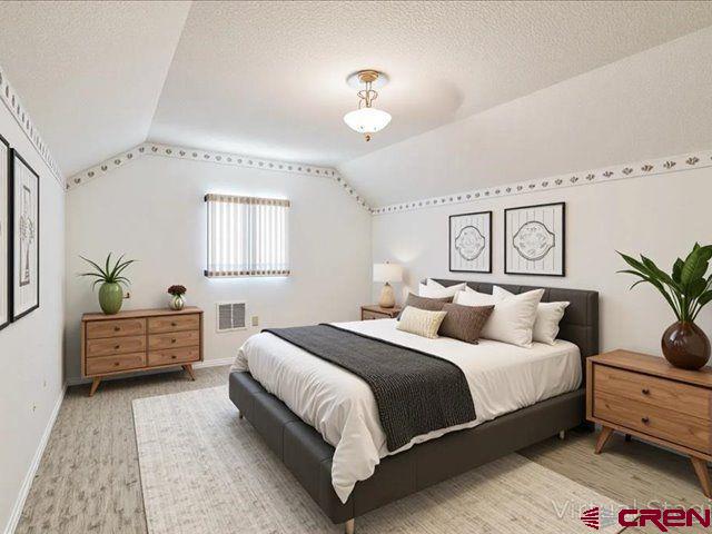 157 S Primrose Ridge Pl, Pagosa Springs, CO 81147 - bedroom with lofted ceiling, baseboards, a textured ceiling, and wood finished floors