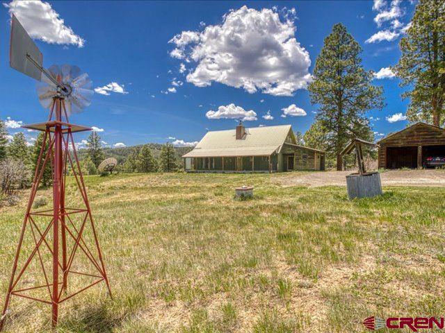 157 S Primrose Ridge Pl, Pagosa Springs, CO 81147 - view of green lawn featuring an outdoor structure and a carport