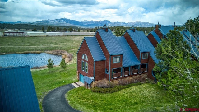 88 W Peregrine Cir Unit 4Unit 1, Pagosa Springs, CO 81147 - view of front of home featuring an attached garage, a chimney, a front lawn, and a water and mountain view