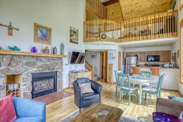 88 W Peregrine Cir Unit 4Unit 1, Pagosa Springs, CO 81147 - living room featuring a high ceiling, stairs, light wood finished floors, a fireplace, and baseboards