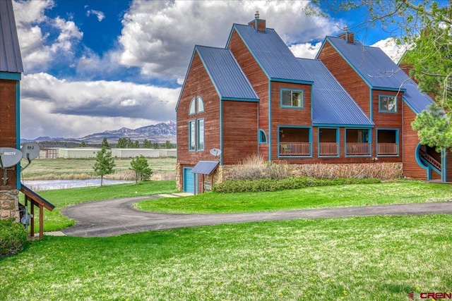 88 W Peregrine Cir Unit 4Unit 1, Pagosa Springs, CO 81147 - view of side of home with a mountain view, a yard, metal roof, a garage, and a chimney