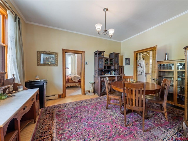 445 4th St, Ouray, CO 81427 - dining room with light wood-type flooring, crown molding, a chandelier, and a baseboard heating unit