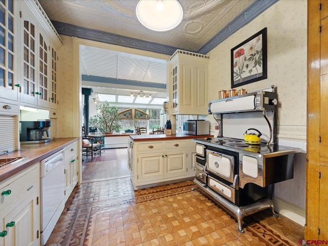 445 4th St, Ouray, CO 81427 - kitchen with wallpapered walls, white dishwasher, wood counters, cream cabinets, and an ornate ceiling