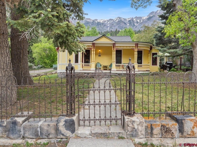 445 4th St, Ouray, CO 81427 - victorian house with a porch, a gate, a fenced front yard, and a mountain view