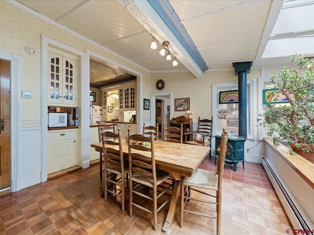 445 4th St, Ouray, CO 81427 - dining room featuring a baseboard heating unit, a wood stove, and a wainscoted wall