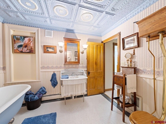 445 4th St, Ouray, CO 81427 - full bathroom featuring wallpapered walls, a soaking tub, a baseboard heating unit, an ornate ceiling, and vanity