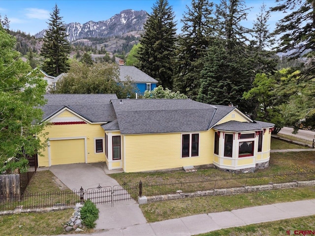 445 4th St, Ouray, CO 81427 - view of front of home featuring a garage, driveway, a shingled roof, a mountain view, and a gate