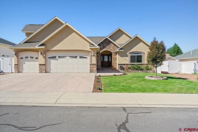 2224 American Way, Montrose, CO 81401 - view of front facade with stone siding, a garage, driveway, and stucco siding