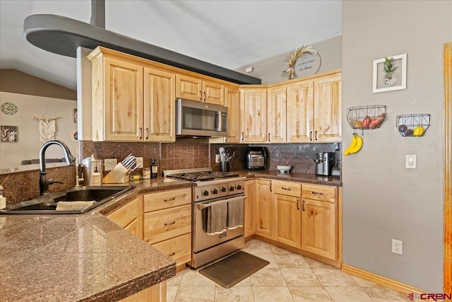 2224 American Way, Montrose, CO 81401 - kitchen featuring stainless steel appliances, a sink, light brown cabinetry, vaulted ceiling, and backsplash