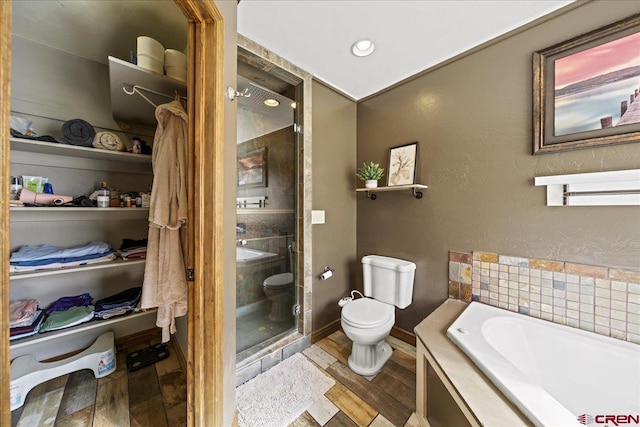 2224 American Way, Montrose, CO 81401 - full bathroom with toilet, a bath, wood finished floors, a textured wall, and a shower