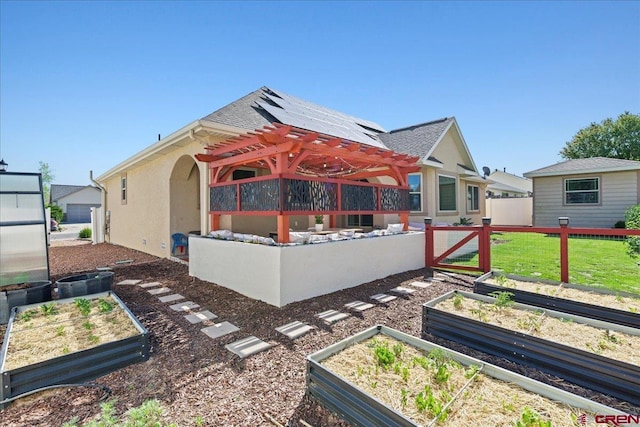 2224 American Way, Montrose, CO 81401 - back of house featuring a garden, roof mounted solar panels, a pergola, and stucco siding