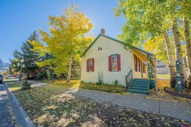 418 Elk Ave, Crested Butte, CO 81224 - view of front facade featuring stucco siding and a chimney