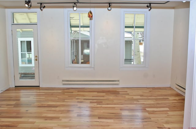 418 Elk Ave, Crested Butte, CO 81224 - unfurnished room featuring a baseboard radiator, light wood-style floors, healthy amount of natural light, and rail lighting