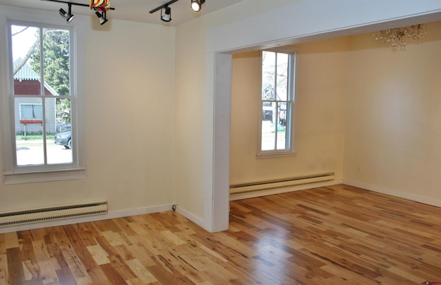418 Elk Ave, Crested Butte, CO 81224 - empty room with a baseboard radiator, baseboard heating, a chandelier, and light wood-style floors