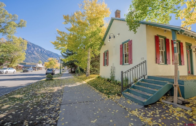 418 Elk Ave, Crested Butte, CO 81224 - view of home's exterior with stucco siding, a mountain view, and a chimney