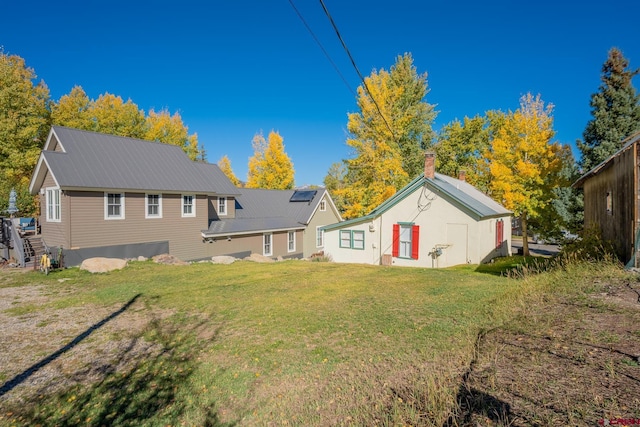 418 Elk Ave, Crested Butte, CO 81224 - back of property featuring a lawn and metal roof