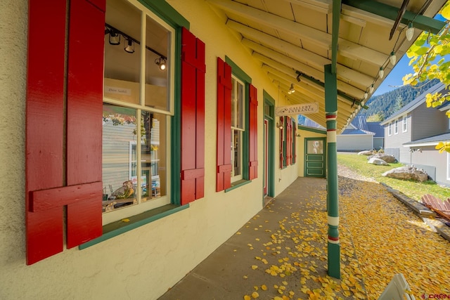 418 Elk Ave, Crested Butte, CO 81224 - view of side of property with a mountain view, stucco siding, and a porch