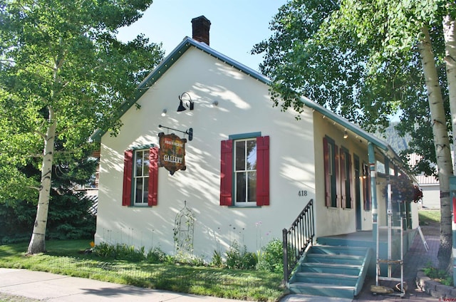 418 Elk Ave, Crested Butte, CO 81224 - view of side of home with a chimney and stucco siding
