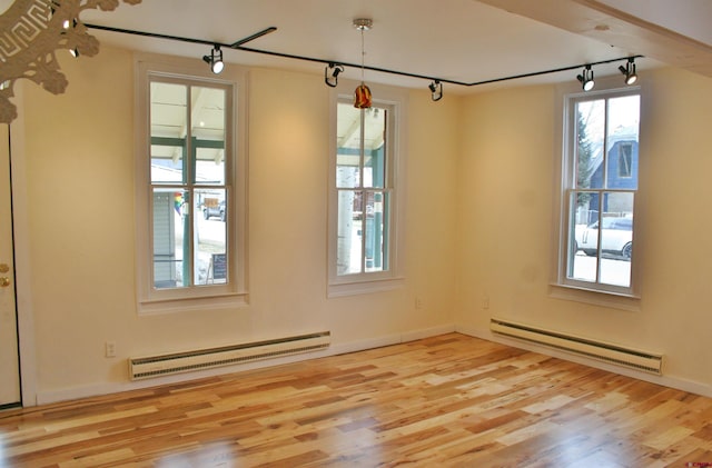418 Elk Ave, Crested Butte, CO 81224 - empty room with a baseboard radiator, a baseboard heating unit, rail lighting, wood finished floors, and baseboards