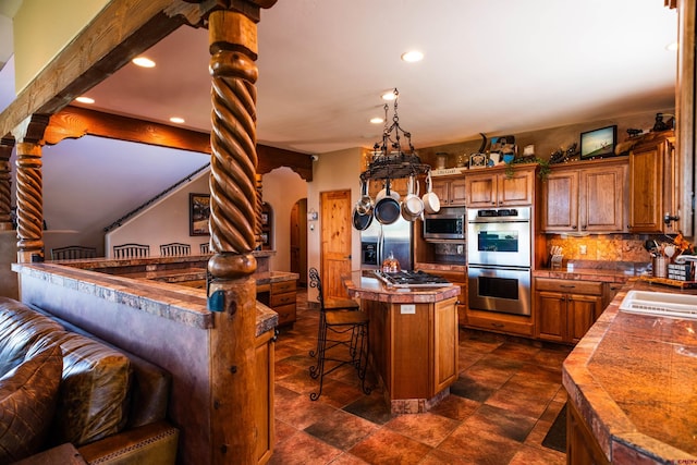 650 County Road 520, Bayfield, CO 81122 - kitchen with stainless steel appliances, brown cabinetry, recessed lighting, a center island, and a kitchen breakfast bar