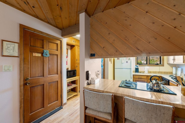 15 Marcellina Ln # 120, Mount Crested Butte, CO 81225 - kitchen featuring black appliances, light wood-style floors, light countertops, wooden ceiling, and a peninsula