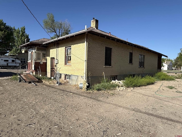 840 Hastings St, Delta, CO 81416 - view of property exterior featuring brick siding and a chimney