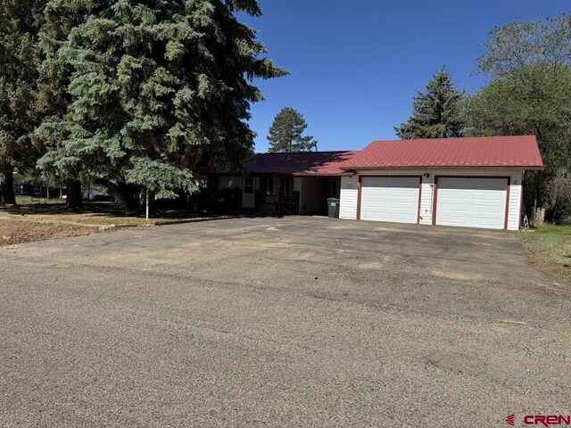 1010 N Dove St, Dove Creek, CO 81324 - view of front facade featuring driveway, a garage, and metal roof