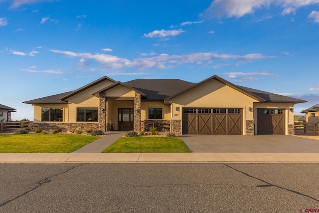 837 Courthouse Peak Ln, Montrose, CO 81403 - view of front of house featuring stone siding, a garage, driveway, and stucco siding