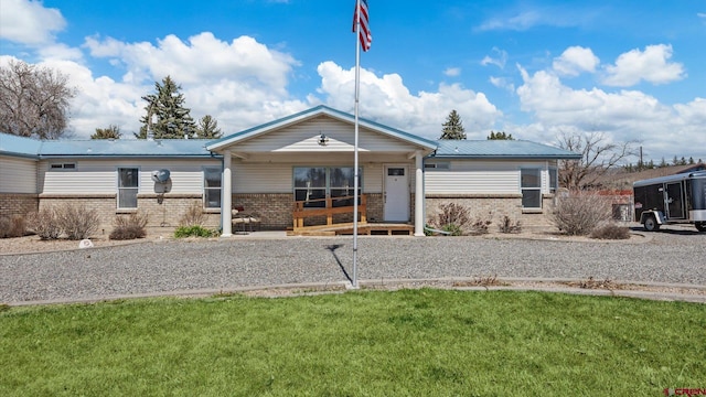180 SE Frontier Ave, Cedaredge, CO 81413 - ranch-style house with brick siding, covered porch, metal roof, and a front yard