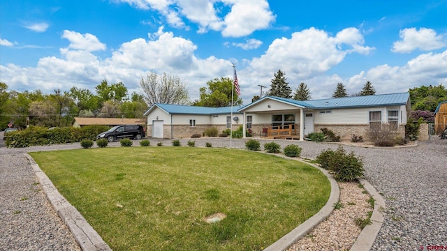 180 SE Frontier Ave, Cedaredge, CO 81413 - ranch-style home with brick siding, a porch, a front yard, and metal roof