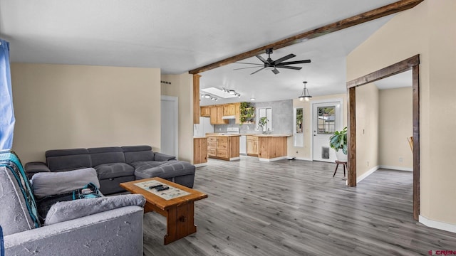 180 SE Frontier Ave, Cedaredge, CO 81413 - living area with wood finished floors, ceiling fan, beamed ceiling, and baseboards