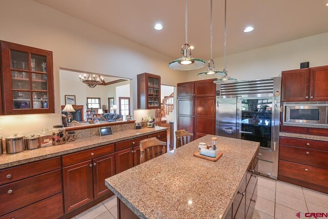 101 E Silver Sage Dr, Crested Butte, CO 81224 - kitchen featuring built in appliances, light tile patterned floors, glass insert cabinets, a center island, and light stone countertops