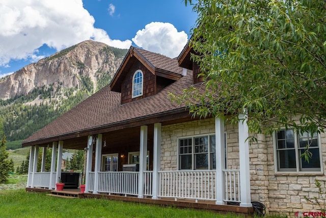 101 E Silver Sage Dr, Crested Butte, CO 81224 - view of front of house featuring stone siding, covered porch, and a mountain view