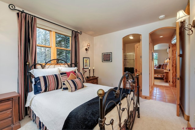 536 Journeys End Rd, Crested Butte, CO 81224 - bedroom featuring arched walkways, light colored carpet, and connected bathroom